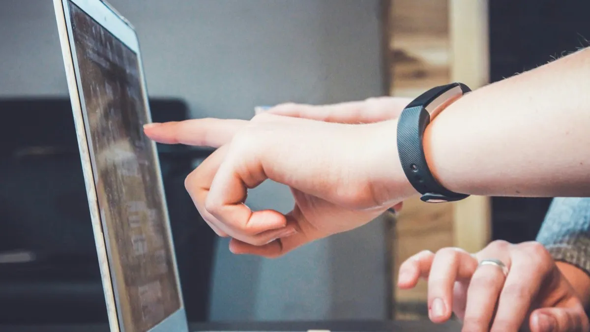 Two people reviewing a website on a laptop screen